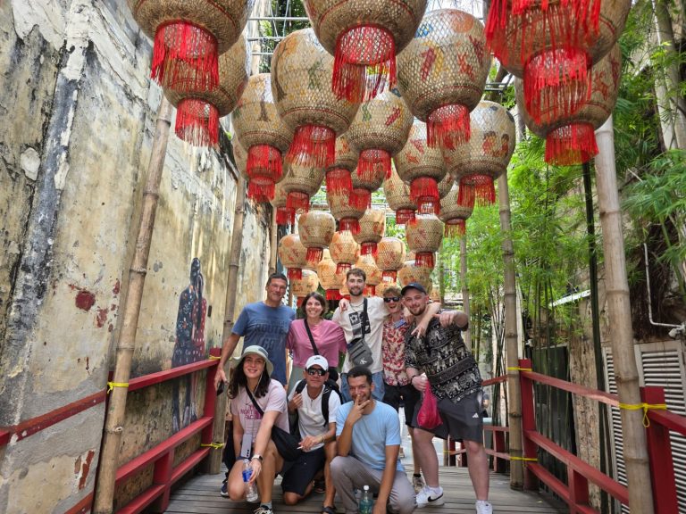 A Travelogue Guesthouse group on the red footbridge under the lanterns at Kwai Chai Hong