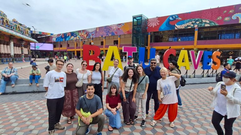 A Travelogue Guesthouse group in front of the Batu Caves sign