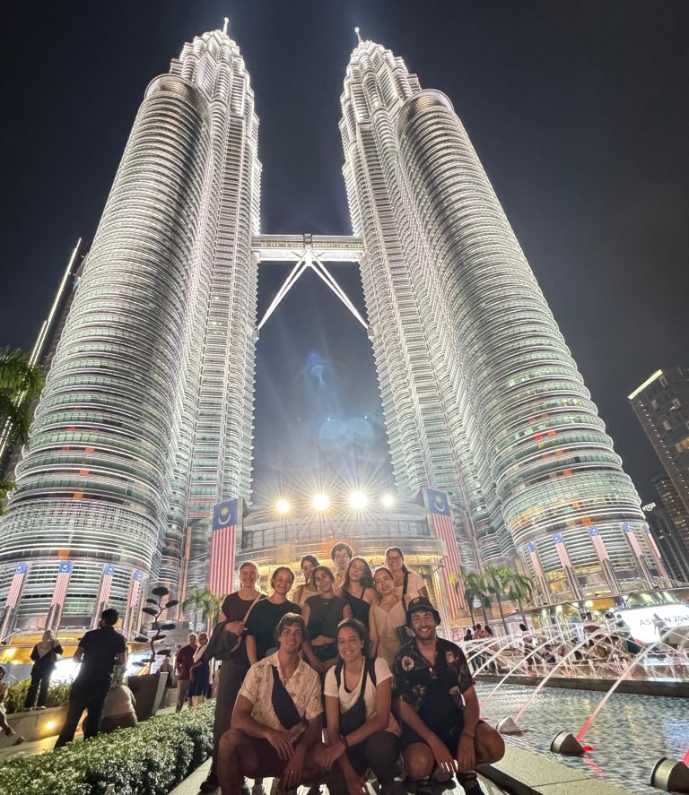 The Petronas Twin Towers from below, a Travelogue Guesthouse group sitting at the foot of them