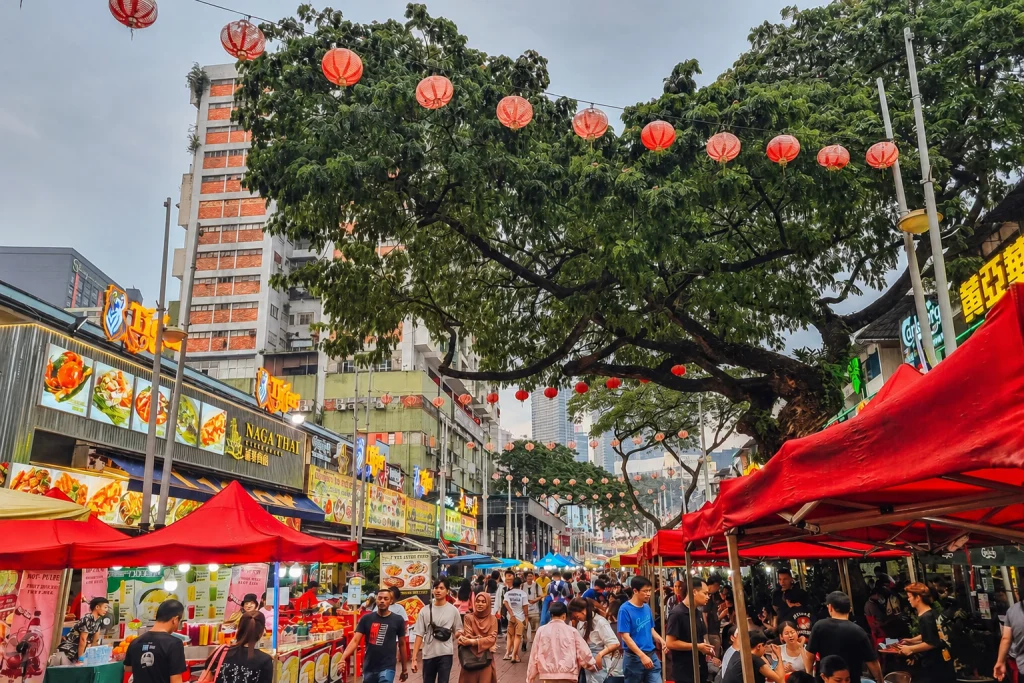 Jalan Alor at night, red lanterns strung the length of the street over the tables and the food stalls