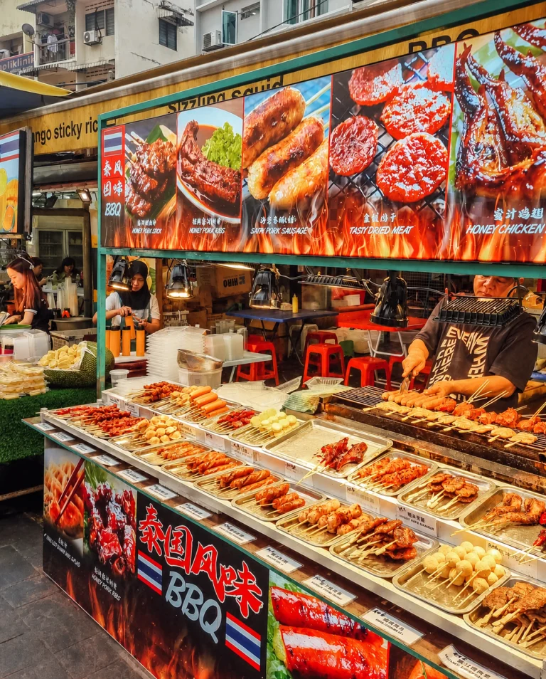 A barbecue and seafood counter on Jalan Alor under its menu boards, Kuala Lumpur