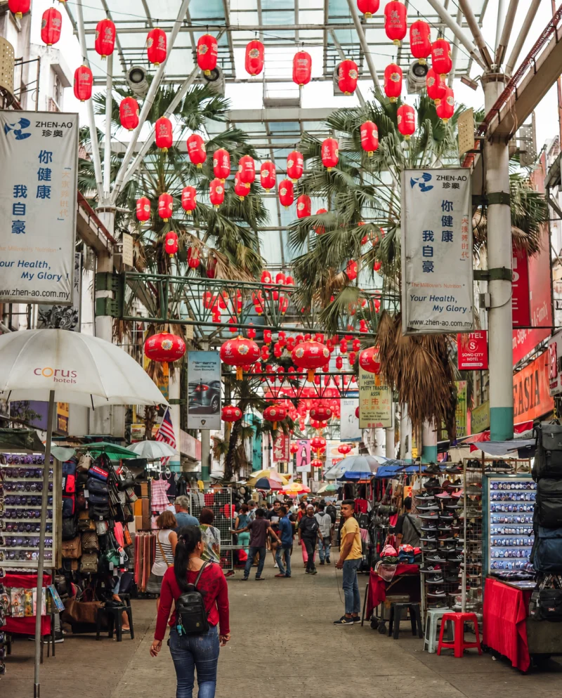 The covered length of Petaling Street market in Kuala Lumpur Chinatown, red lanterns strung above the stalls