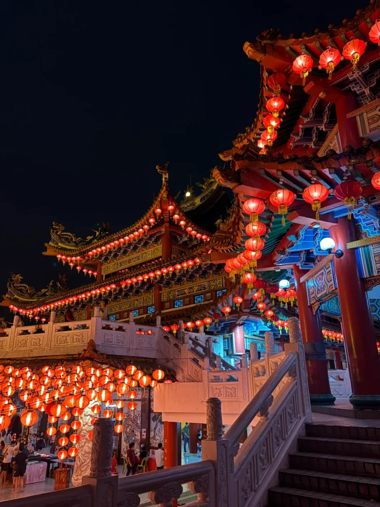 Rows of lit lanterns under the eaves at Thean Hou Temple after dark
