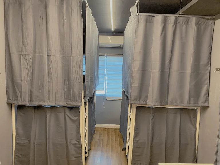 Bunks with privacy curtains drawn in the eight bed dormitory at Travelogue Guesthouse