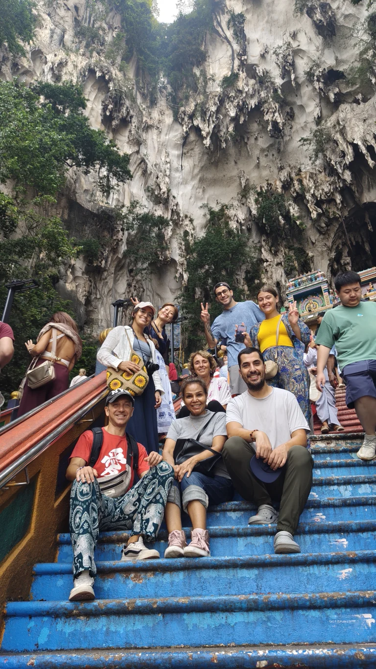 Travelogue Guesthouse guests sitting on the painted steps at Batu Caves, Kuala Lumpur