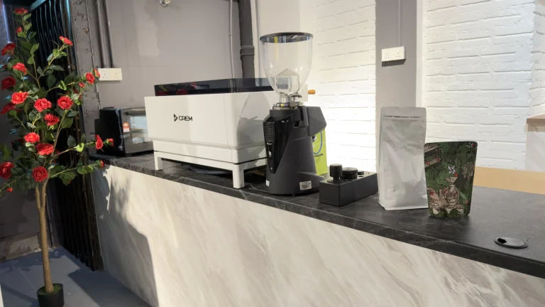 The espresso machine and grinder on the counter of the coffee house at Travelogue Guesthouse, Bukit Bintang