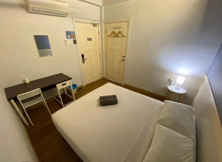 The deluxe room at Travelogue Guesthouse with a desk and a double bed, Bukit Bintang