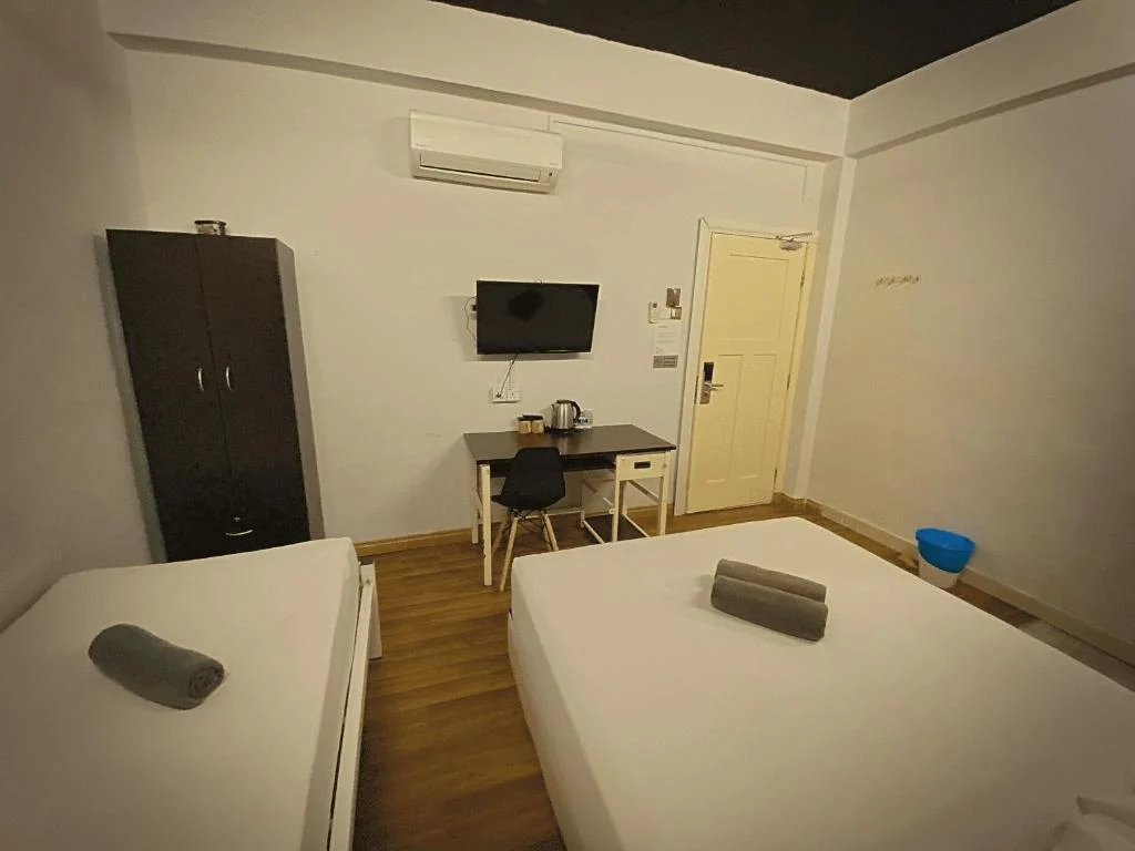 The wardrobe, desk and air conditioning in the family room at Travelogue Guesthouse, Bukit Bintang