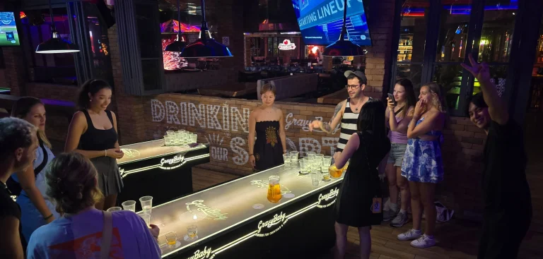 Travelogue Guesthouse guests at a lit bar on a night out in Kuala Lumpur