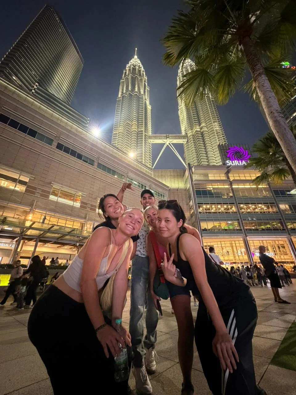 Travelogue Guesthouse guests at KLCC with the towers lit behind them