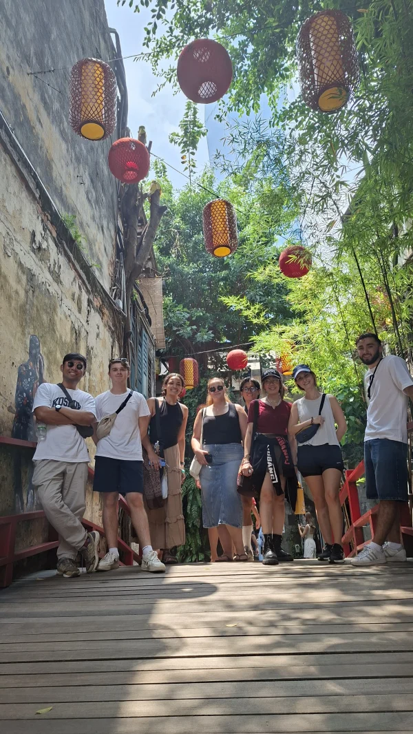 Travelogue Guesthouse guests on the red footbridge under the lanterns at Kwai Chai Hong