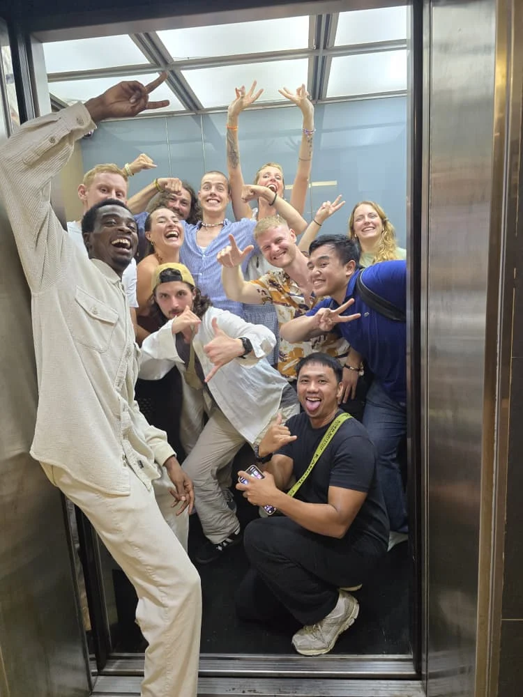 A group of Travelogue Guesthouse guests crowded into the lift on their way out, Bukit Bintang, Kuala Lumpur