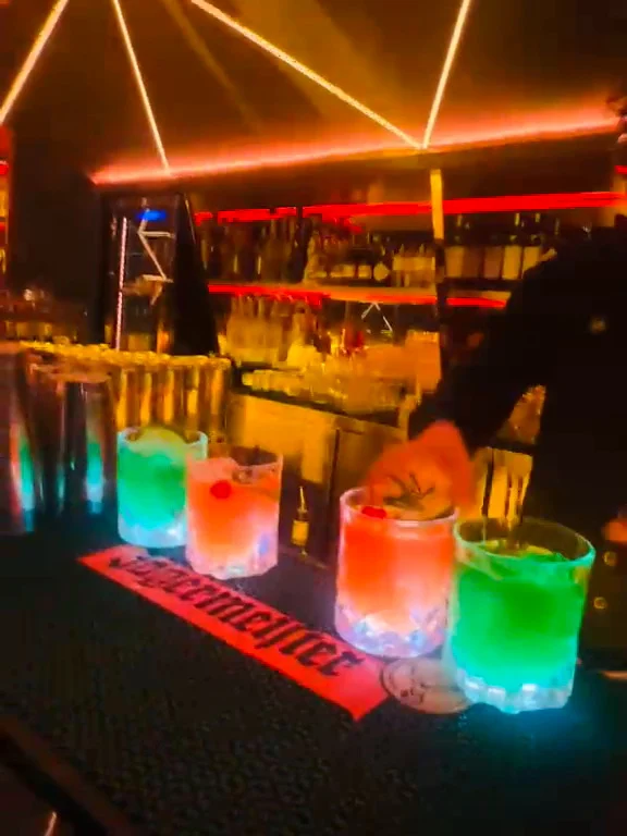 Cocktails lit up along the bar counter on a Travelogue Guesthouse guests' night out