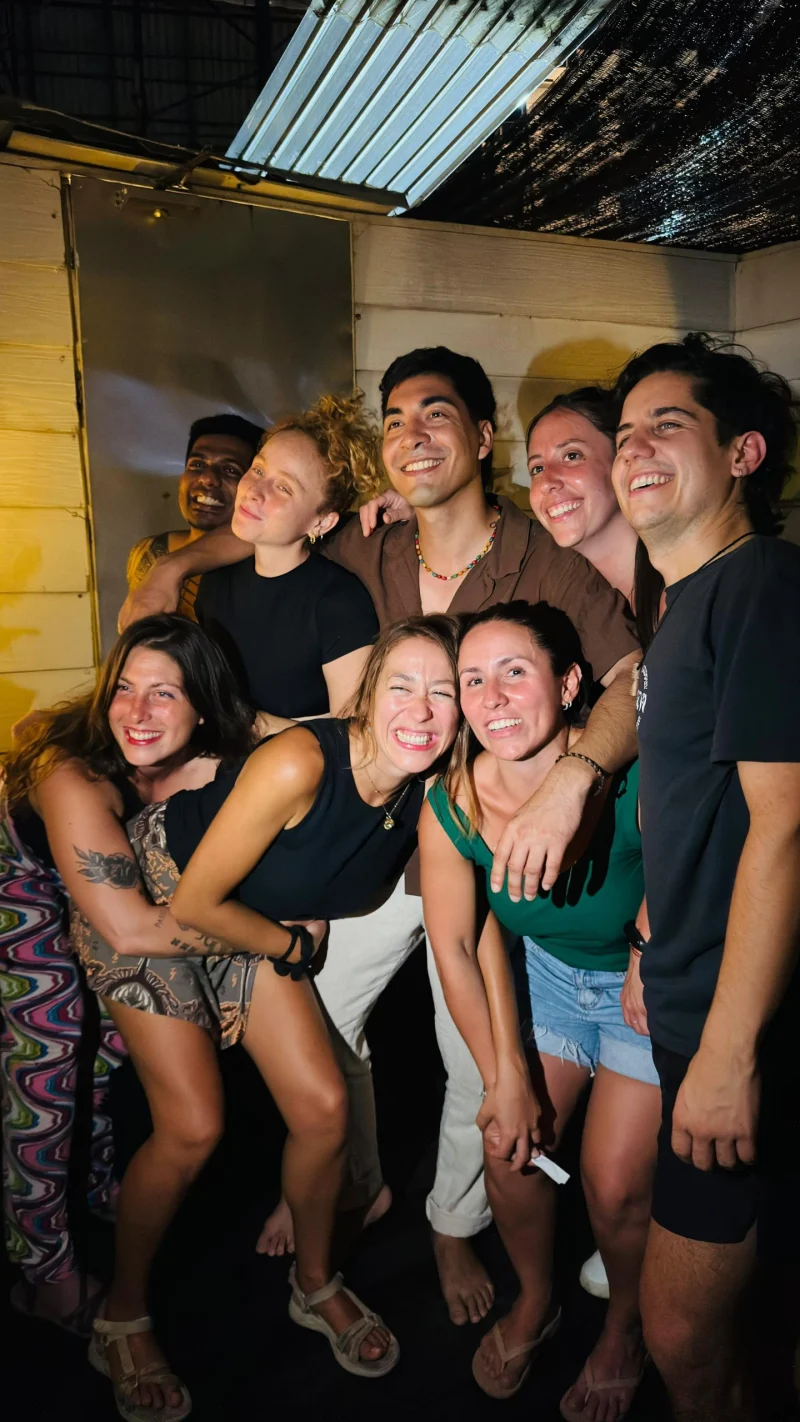 Travelogue Guesthouse guests laughing together with their arms around each other on a night out in Kuala Lumpur