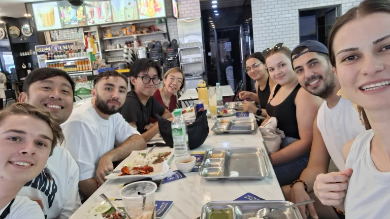 Travelogue Guesthouse guests around one long table at the Jalan Alor group dinner, Kuala Lumpur
