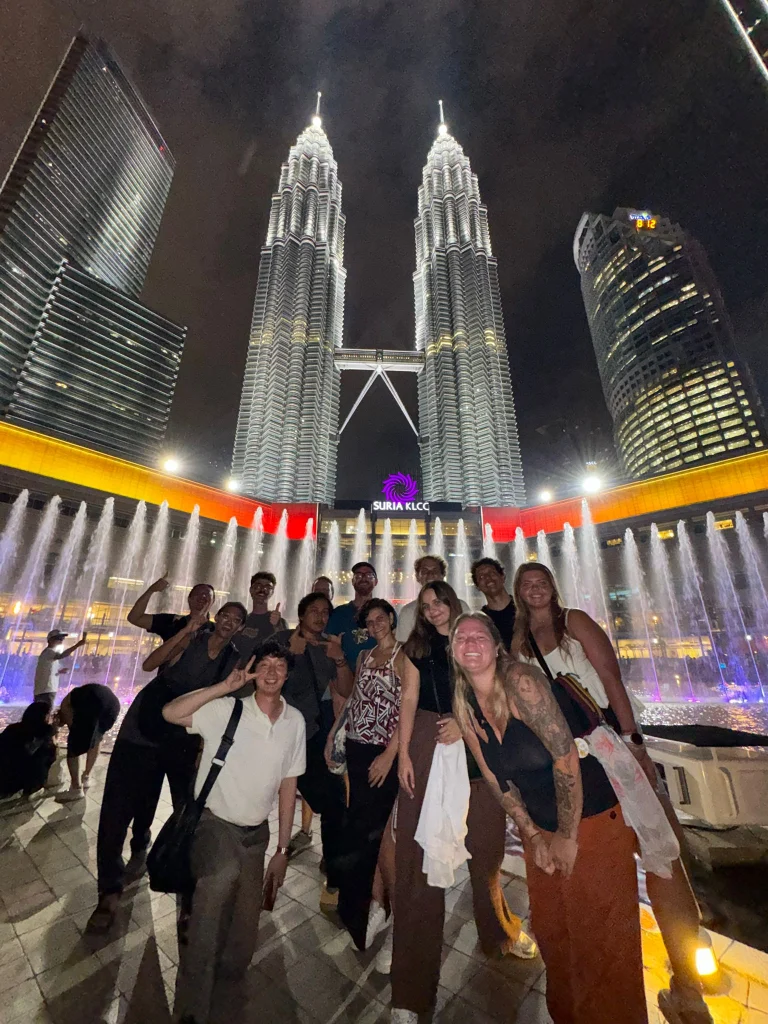 A Travelogue Guesthouse group in front of the KLCC fountain show at night