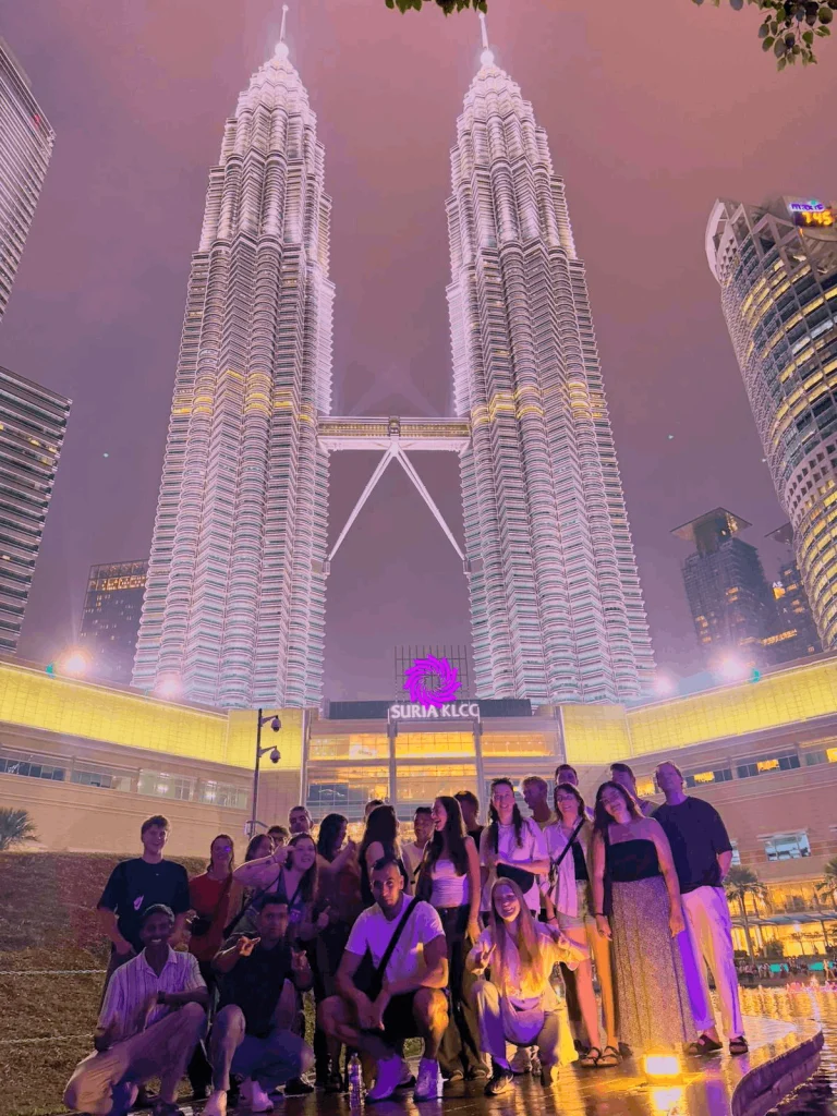 A Travelogue Guesthouse group in front of the KLCC fountains at night