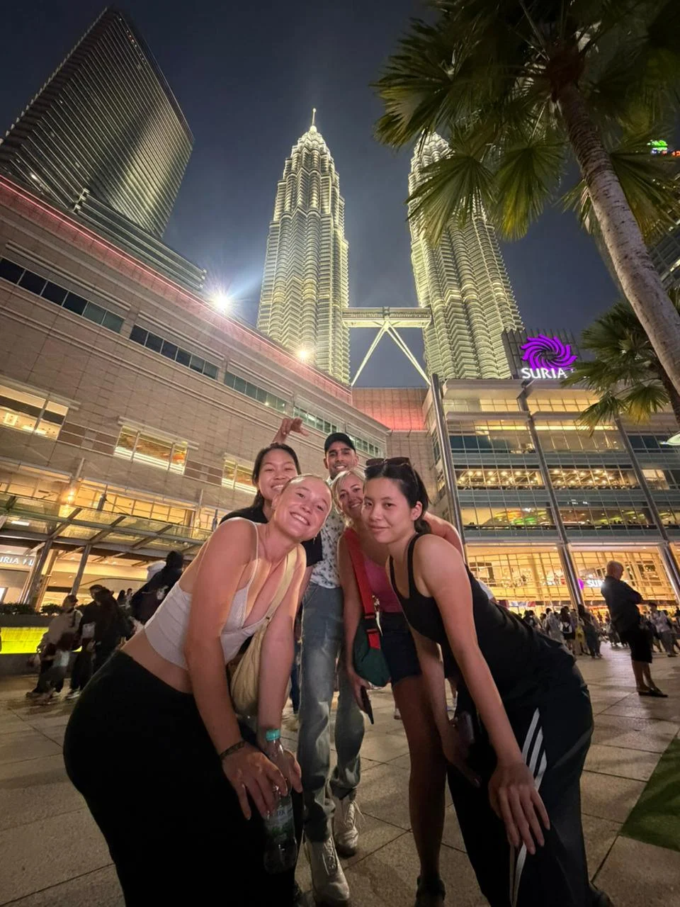 Travelogue Guesthouse guests below the Petronas Twin Towers at night