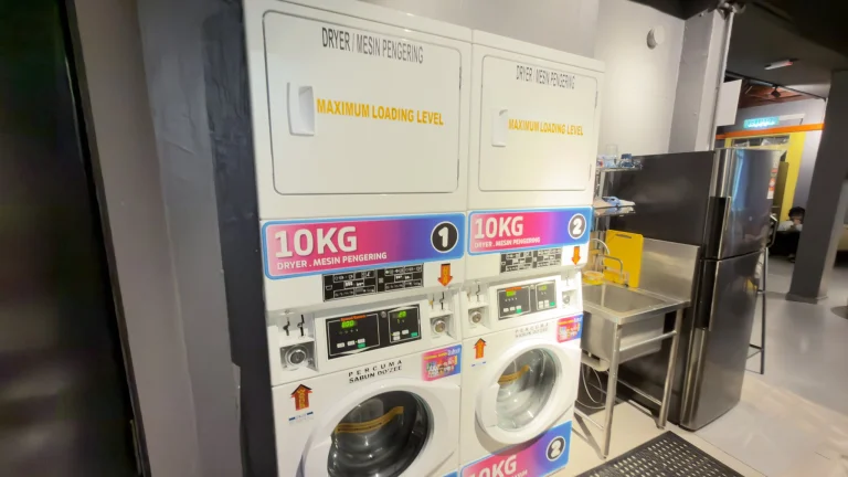 Two stacked washers and dryers, 10 kg each, in the laundry at Travelogue Guesthouse, Bukit Bintang