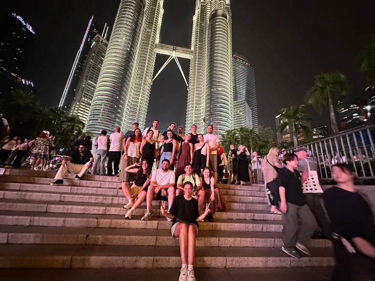 The Petronas Twin Towers lit at twilight above the Travelogue Guesthouse night tour group