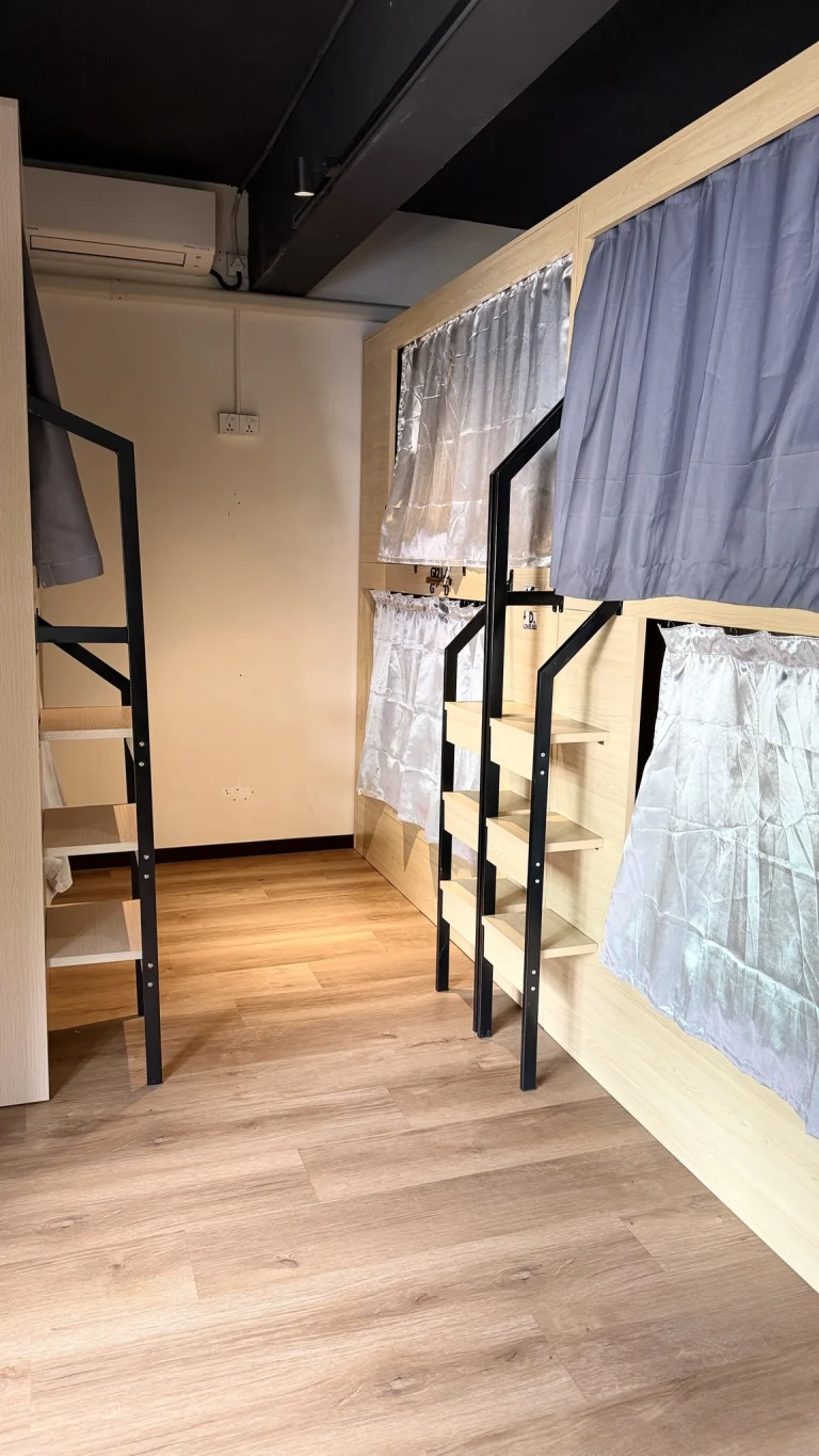 A row of pod bunks with curtains and ladders in the female dormitory at Travelogue Guesthouse, Kuala Lumpur